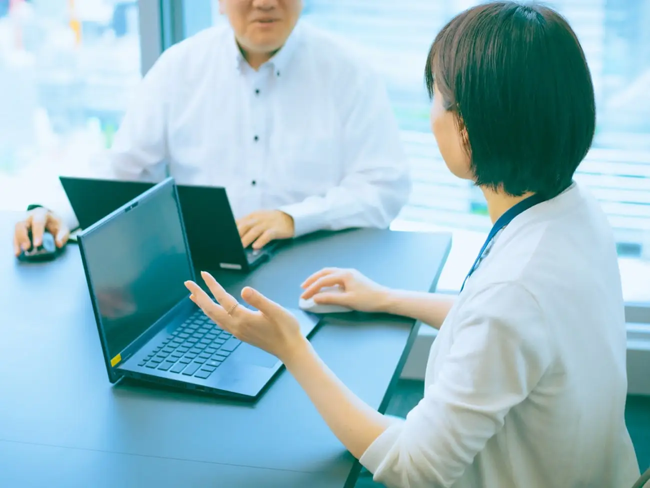 PCを前に会話する社員の写真